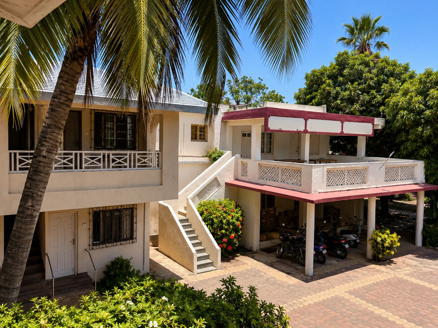 Palm-framed hotel courtyard, verandas, and staircase.